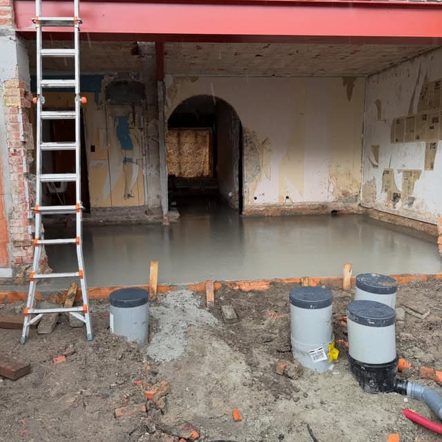 Nieuw betonplateau in een renovatie met rioleringsputten op de voorgrond